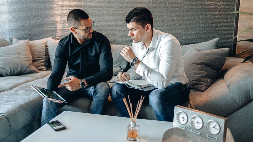 Zwei Menschen sehen gemeinsam auf ein Tablet und Notizen