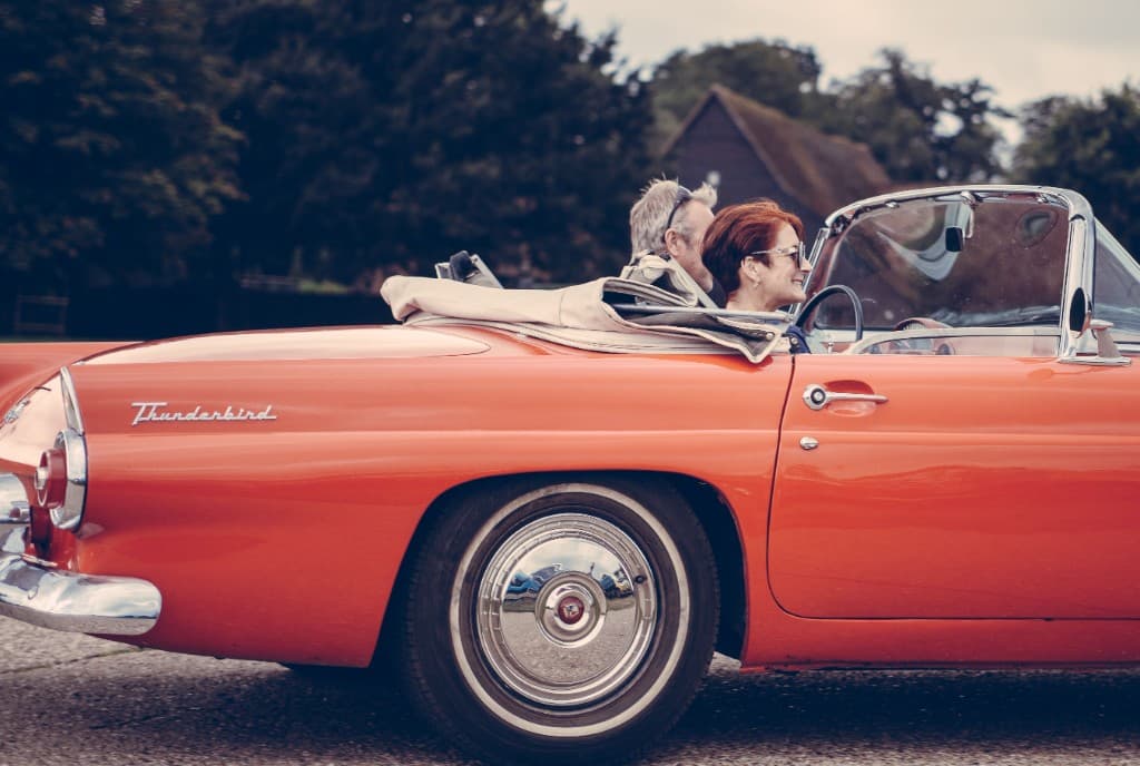 Zwei Personen in einem roten Cabrio